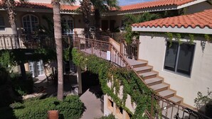 Ein zweistöckiges Haus mit Pool, Außenbereich und einer Treppe mit Geländer.