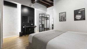 Una habitación de hotel moderna con una cama grande, un escritorio y un armario.