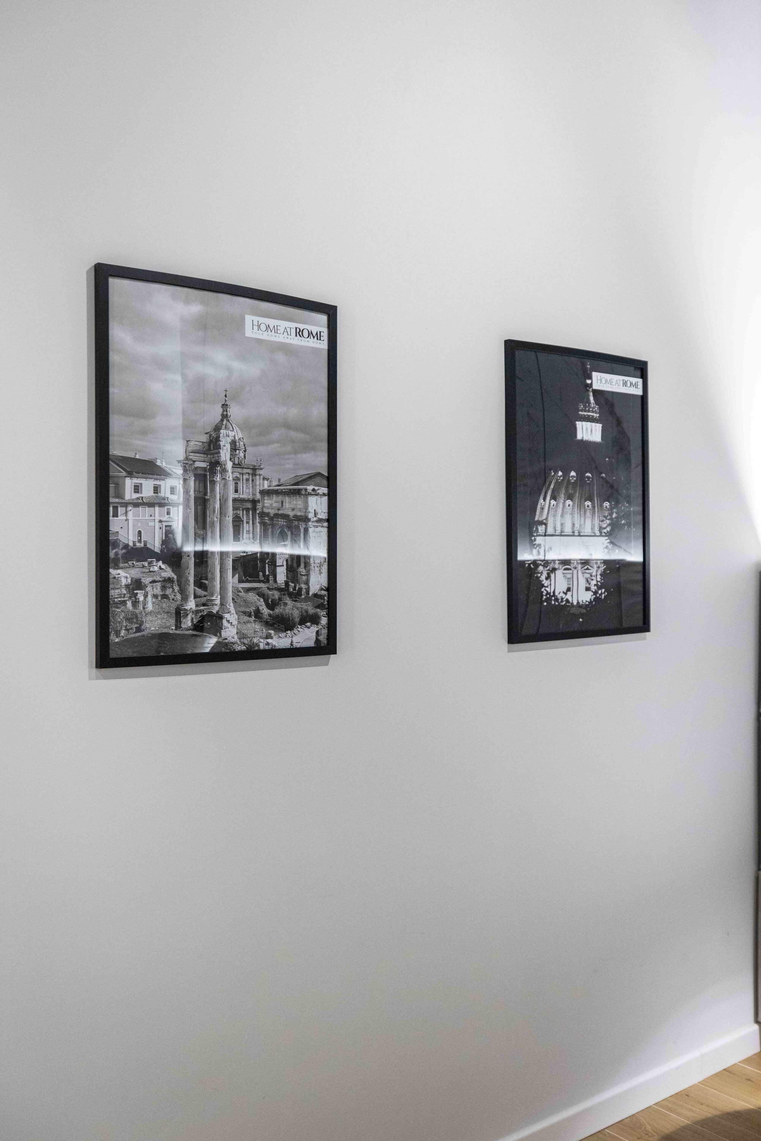 Two framed black and white photographs on a white wall.