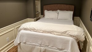 Ein Schlafzimmer mit einem Bett, einem Kopfteil und einem Nachttisch.