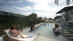 A poolside area with lounge chairs and a seating area by the pool. - The Good Vibes House (Cabo Rojo)