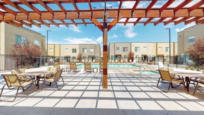 Un área junto a la piscina con mobiliario exterior y una pérgola.