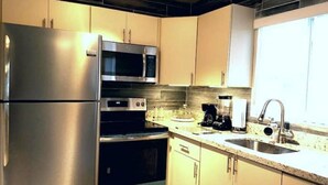 Una cocina moderna con electrodomésticos de acero inoxidable, microondas y cafetera.