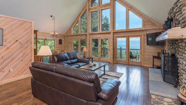 Une pièce spacieuse de style loft, avec un grand plafond en bois, une cheminée et un canapé en cuir.