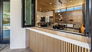 Une cuisine moderne avec des meubles en bois, un îlot central et des luminaires suspendus.