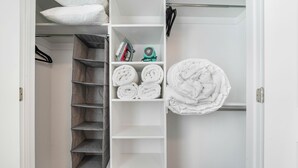 Un dressing avec des étagères, une tringle à vêtements et une serviette enroulée sur la droite.