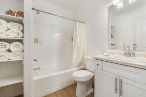 Une salle de bain équipée d’une baignoire, de toilettes et d’un meuble-lavabo avec un miroir.