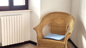 A corner room with a wicker chair, a radiator, and a window. - S296 - Sirolo, studio flat in the center with sea view (Sirolo)