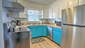Una cocina moderna con un refrigerador de acero inoxidable, una cafetera y un horno empotrado.