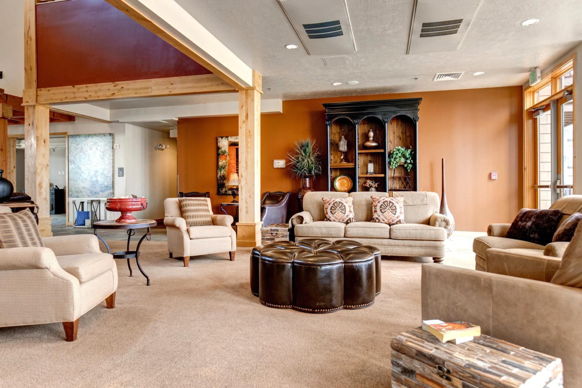 Un salon spacieux avec un haut plafond, une cheminée et une grande fenêtre.