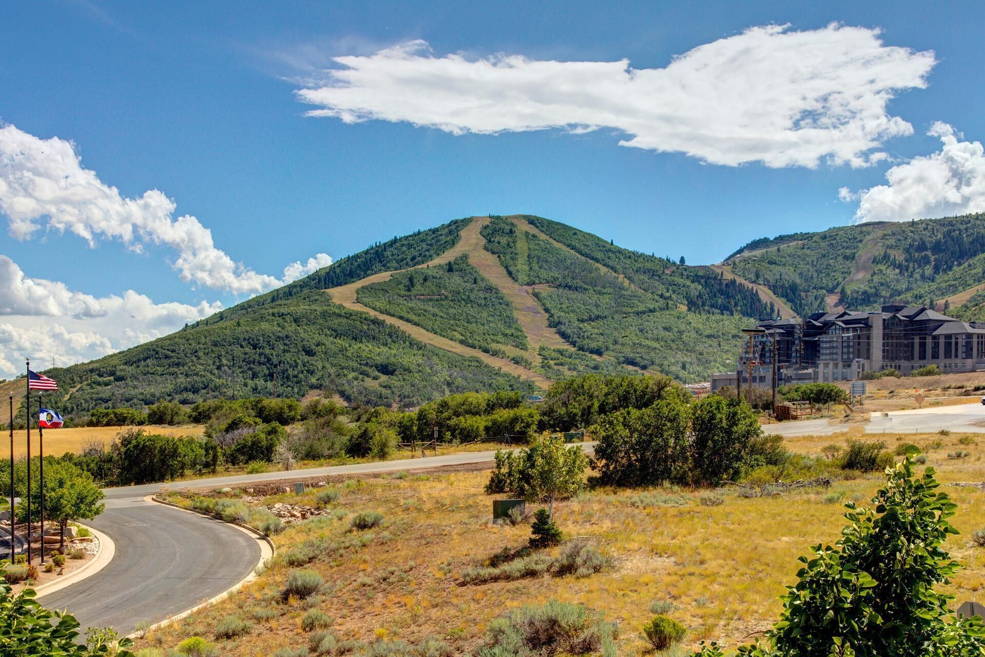 A hotel with a modern design, situated in a hilly area with a clear sky.