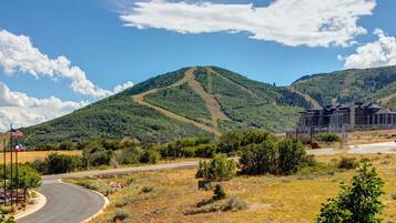 A hotel with a modern design, situated in a hilly area with a clear sky.