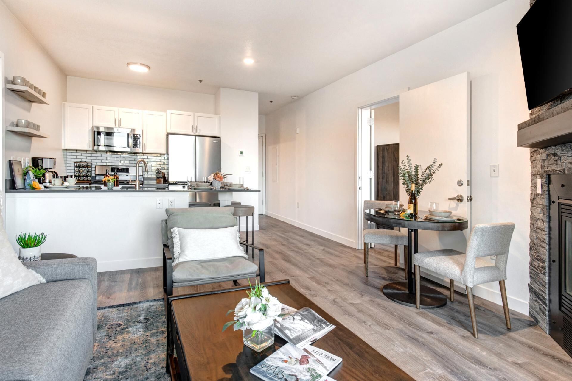 A modern living room with a sofa, a coffee table, and a dining area with chairs.