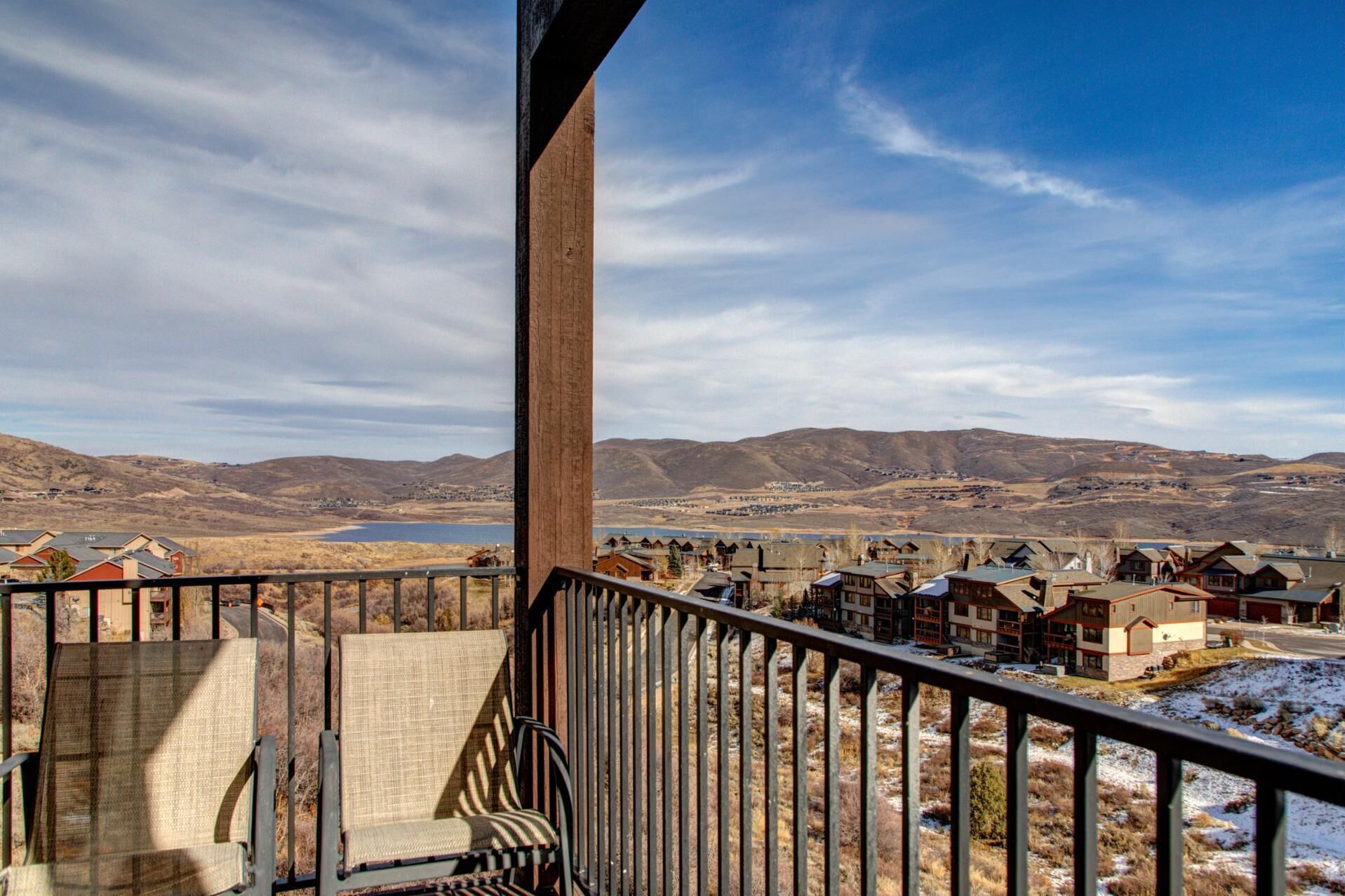 A balcony with a view of a town and mountains.