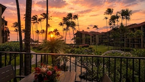 A hotel with a view of the sunset, palm trees, and a pool area. - Papakea Resort by KBM (Lahaina)