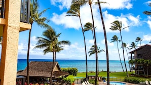 A resort with a pool, palm trees, and a view of the ocean. - Papakea Resort by KBM (Lahaina)
