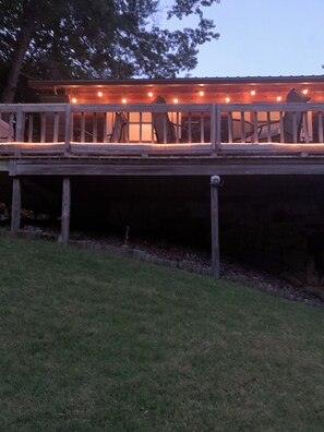 Eine Holzterrasse mit Geländern und Lichterketten.
