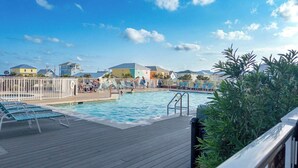 Et poolområde med liggestole og en træterrasse.
