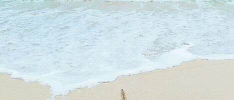 A beach with the word "BIMINI" and a heart drawn in the sand.
