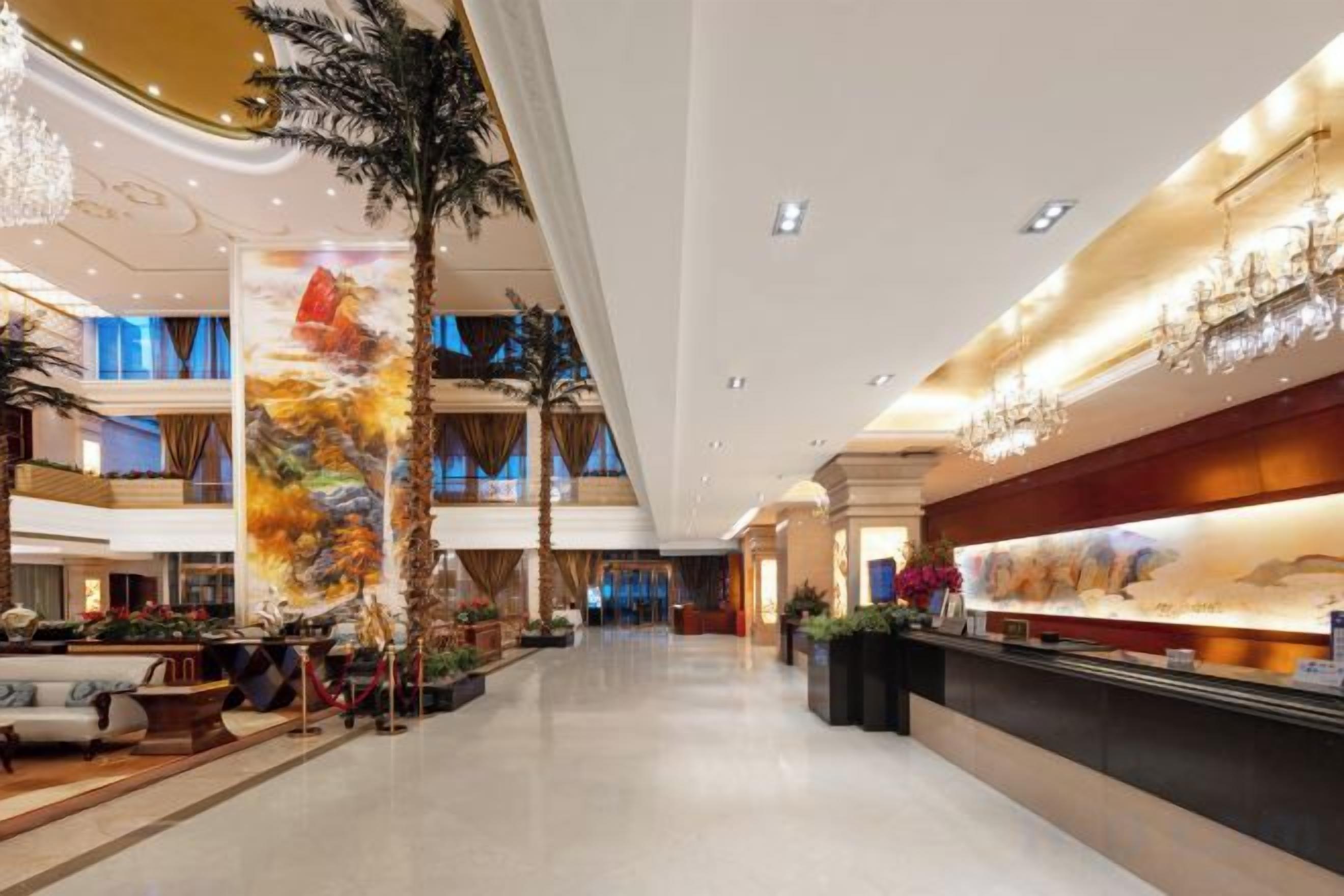 Un vestíbul ample amb taulell d'informació, zona de seients i un mural gran.