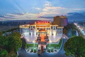 A hotel with a large entrance, multiple floors, and a parking area. - Riverside Hotel (Taizhou)