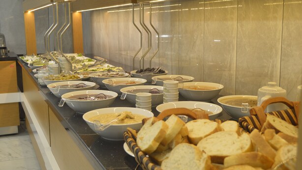 A buffet with various food items and bread baskets. - Quars Garden Hotel (Düzce)