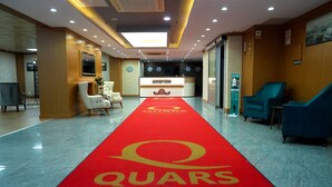 A hotel reception area with a red carpet, reception desk, and seating. - Quars Garden Hotel (Düzce)