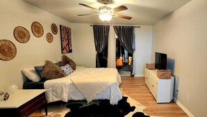 A bedroom with a bed, a desk, a TV, and a ceiling fan. - Beautiful and peaceful Lake house (Inverness)
