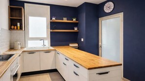 A modern kitchen with white cabinets, wooden countertops, and built-in shelves. - Lovely 1-Bed Apartment in lac1 Tunis (Tunis)