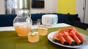 A table with a pitcher, glasses, and a plate of watermelon slices. - Pirgos Colorful Studio, Sleeps 2, Parking WiFi Ac (Pirgos Monofatsiou Heraklion)