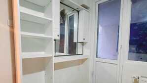 A room with a white wardrobe, a window with a view, and a radiator. - Lovely 1-Bed Apartment (Istanbul)