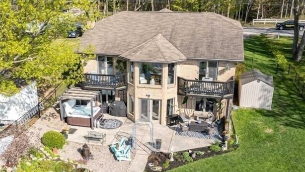 A two-story house with a patio area, outdoor seating, and a hot tub. - Wasaga Beach cottage  (Wasaga Beach)