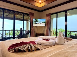Una habitación de hotel con cama, televisión y vista al exterior.