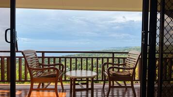 Un balcon avec deux chaises en bois et une petite table, offrant une vue sur un paysage pittoresque.