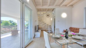 A modern interior with a dining area, a staircase, and a balcony. - Golden Terrace Leggiuno 2BR/2BA Walk to the Lake, Leggiuno, Italy (Leggiuno)
