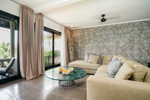 Villa básica, 2 camas de matrimonio | Zona de estar | Una televisión