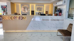 A reception area with a marble floor, a reception desk, and a seating area. - Sananwan Hometel (Bang Phli)