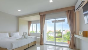 A modern hotel room with a large bed, a balcony with curtains, and a city view. - Sananwan Hometel (Bang Phli)