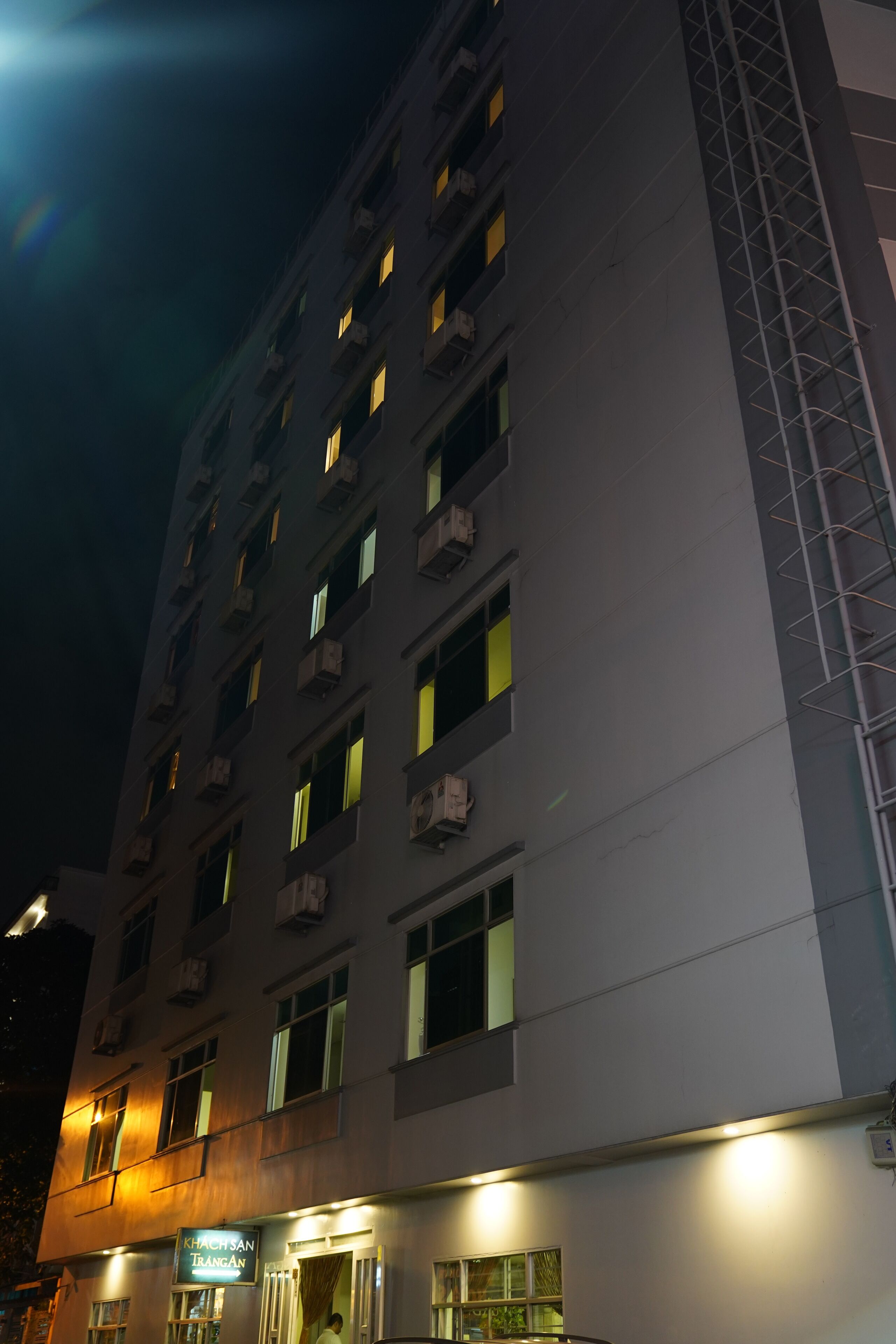A multi-story building with illuminated windows and a visible entrance.