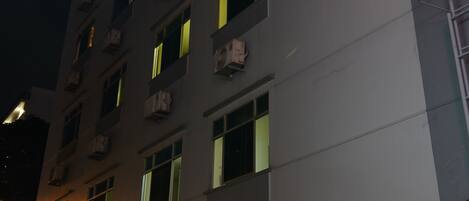 A multi-story building with illuminated windows and a visible entrance.