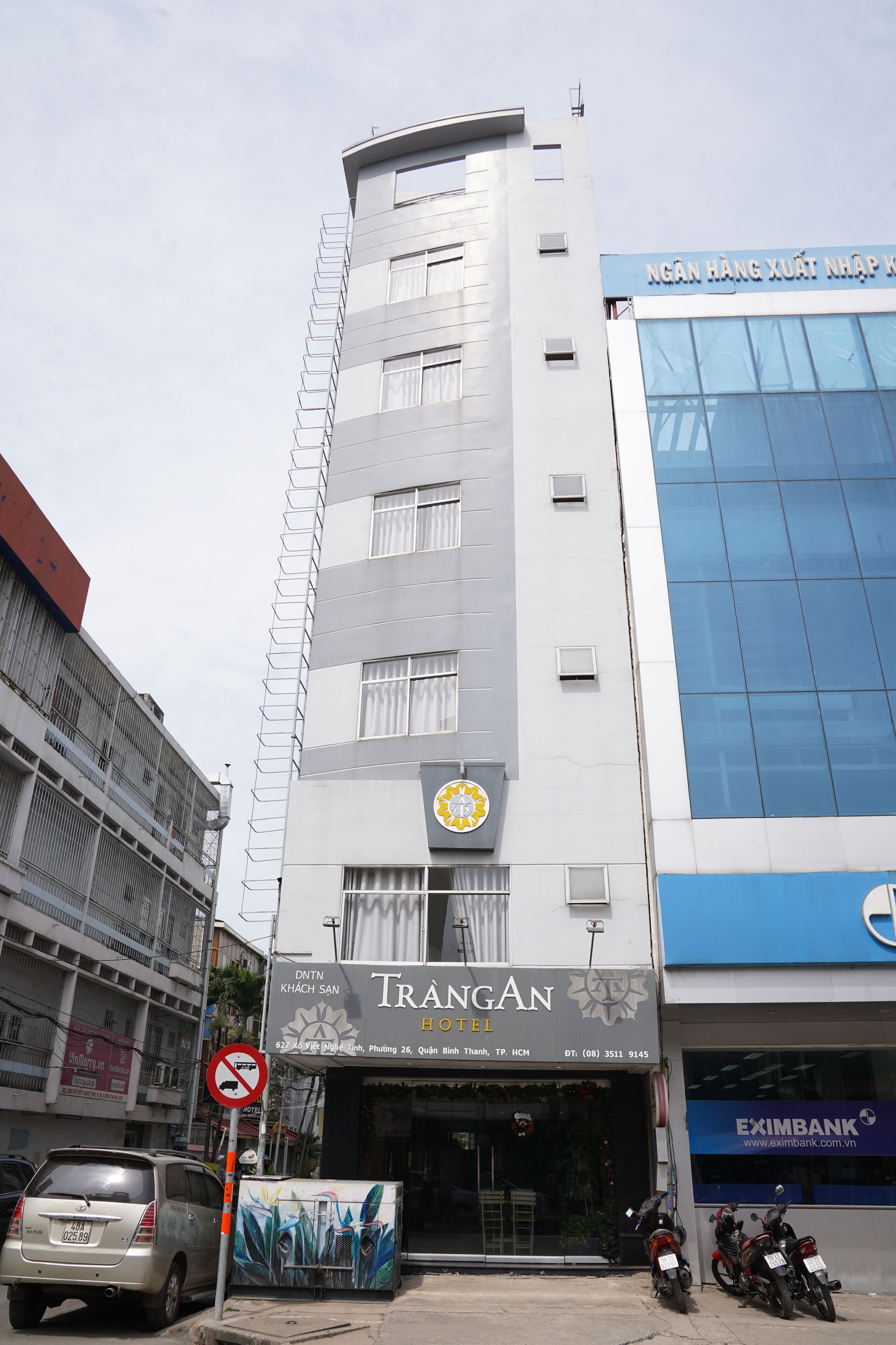 A hotel with a modern facade, a visible logo, and a sign for Trangan Hotel.