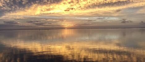 A calm body of water reflecting the sky during sunset.