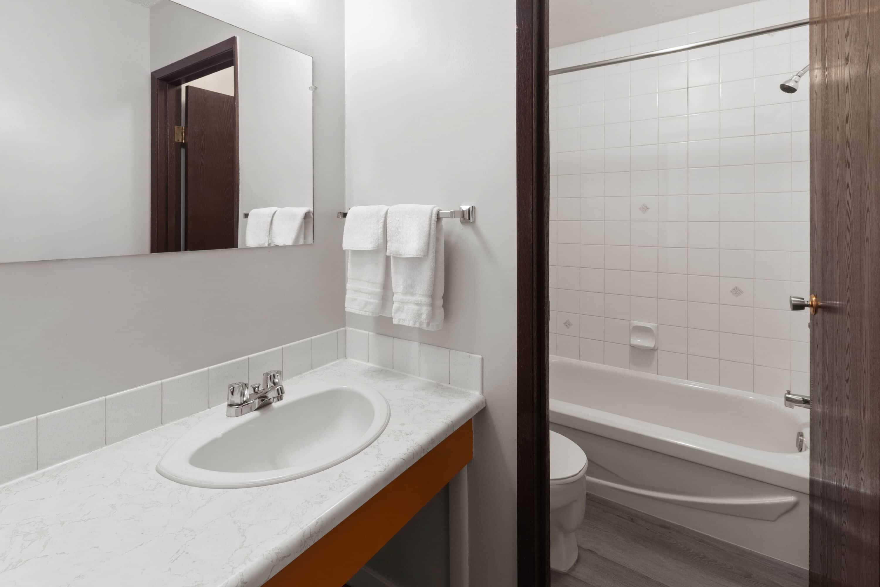 Un baño moderno con lavamanos de mármol, inodoro y bañera.