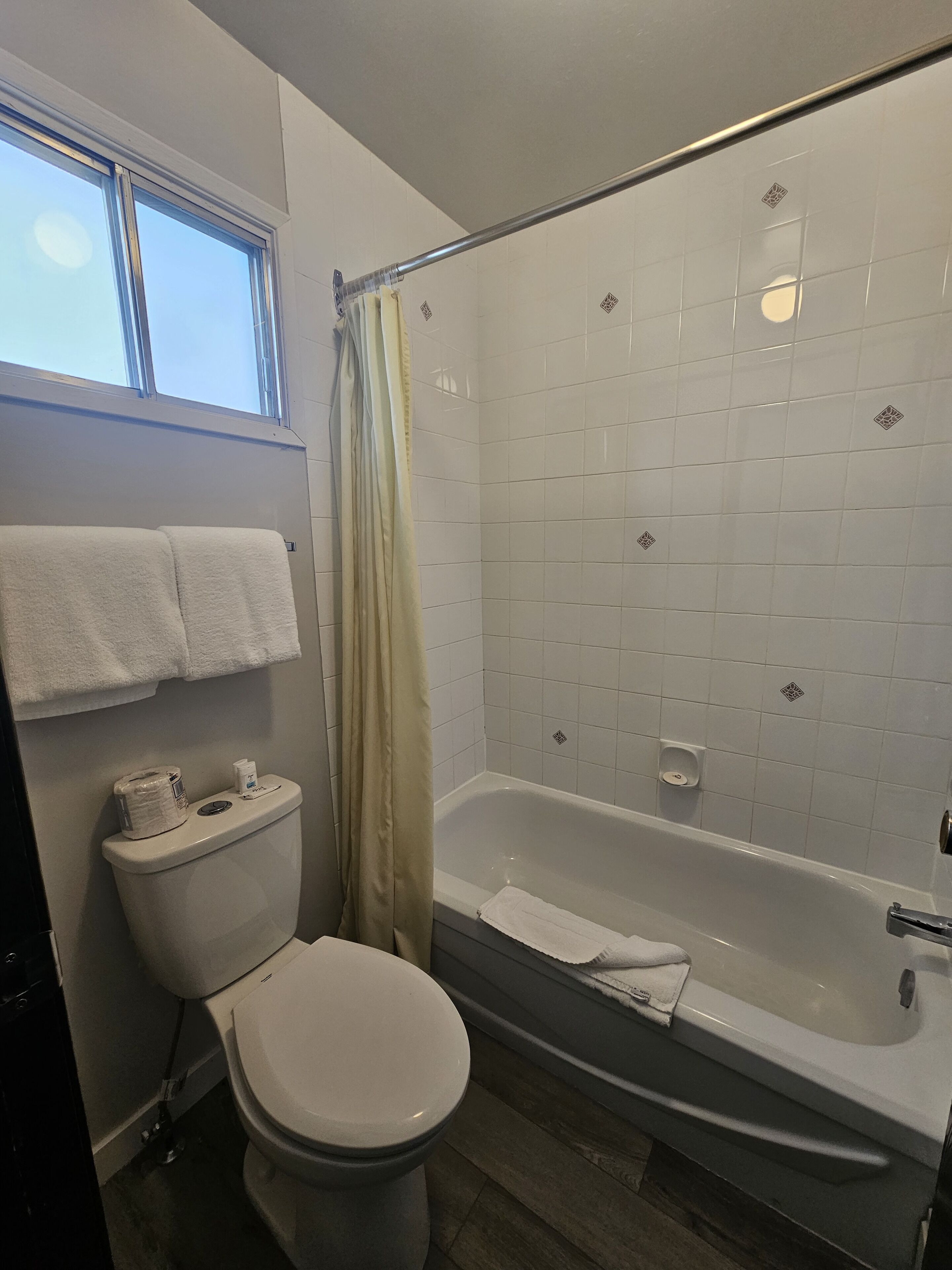 Een badkamer met een toilet, een bad en een douchegordijn.