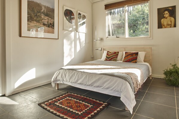 A bedroom with a bed, a window, and a door. - A bright spacious private timber cabin, on a beautiful 11acre off-grid property! (Reidsdale)