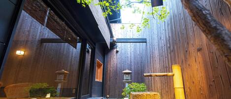 A traditional wooden building with a wooden deck, lanterns, and a stone lantern.