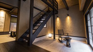 Eine Treppe mit Holzwertlauf und einem Stuhl in einem Raum mit strukturierter Wand und einem Fenster.