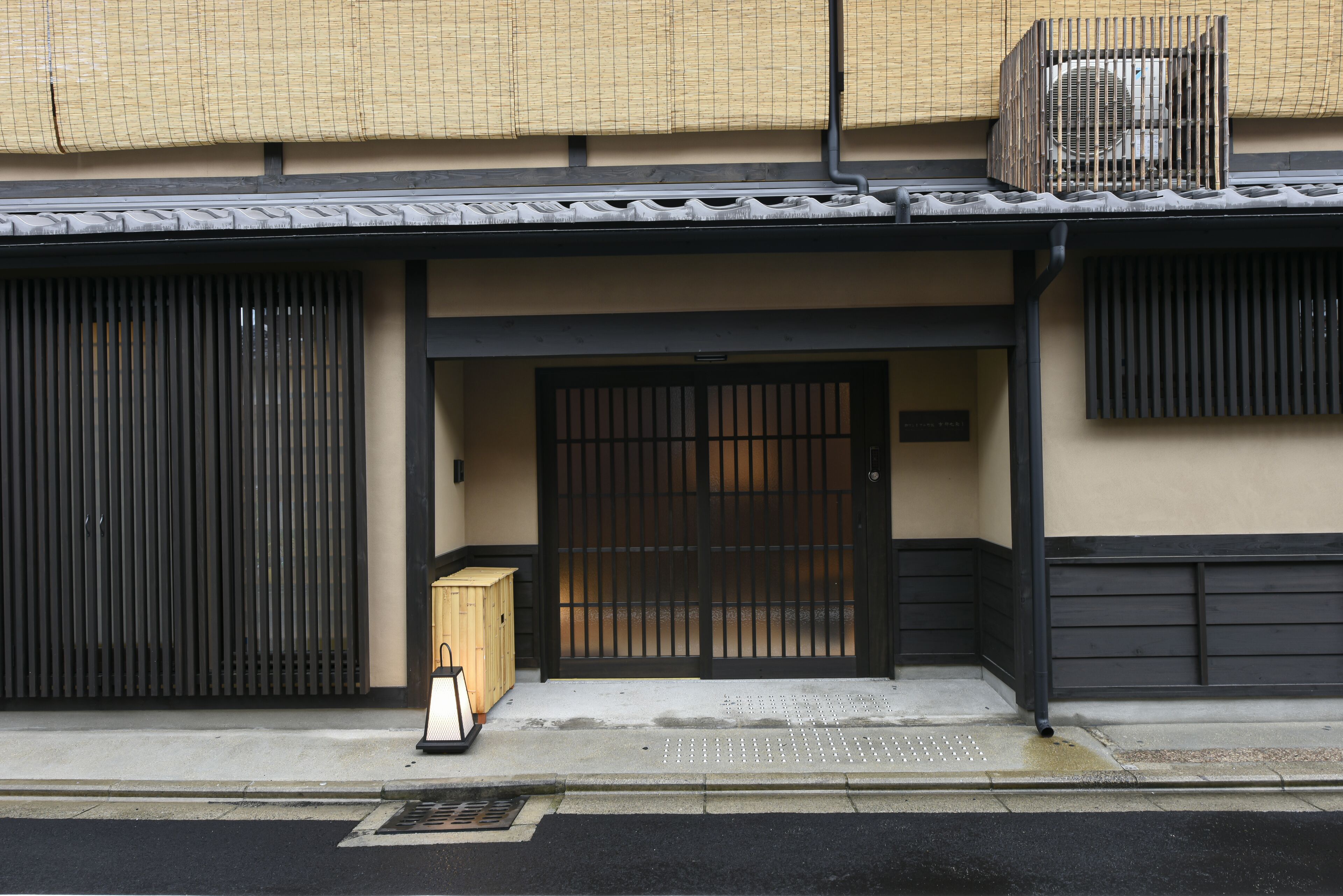 Een traditioneel Japans gebouw met een zwart hekwerk, een houten kast en een pannendak.