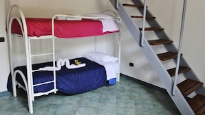 Une chambre de dortoir avec des lits superposés, un escalier et un revêtement de sol carrelé.
