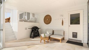 A modern interior with a staircase, a sofa, a coffee table, and a scooter.